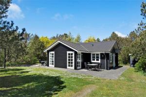 a black cabin with a picnic table in a yard at LF584-Hurup-Thy-Haettemagevej-4 in Sindrup