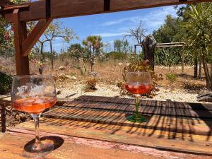 two glasses of wine sitting on a wooden table at Casa do Avô António in Bensafrim