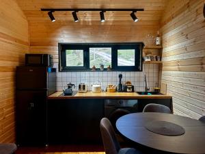 a kitchen with a refrigerator and a table with chairs at Uno Cottage Kazbegi in Kazbegi +9 photos
