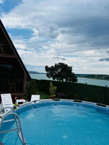 a swimming pool with chairs and a view of the water at Nakas cottage in Tbilisi City