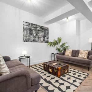 a living room with two couches and a suitcase on a rug at Modern 3 Bed Townhouse - Wolverhampton Centre - Gated Development - Bedroom TV 1CO in Wolverhampton