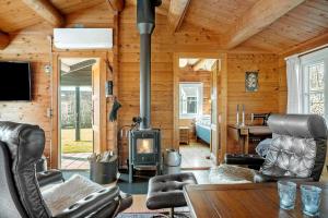 a living room with a fireplace in a log cabin at LF609-Hurup-Thy-Bakkesiden-9 in Doverodde