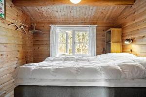 a large white bed in a room with a window at LF609-Hurup-Thy-Bakkesiden-9 in Doverodde