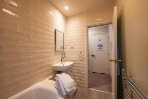 a bathroom with a sink and a toilet and a tub at The Goddard Arms in Swindon +54 photos