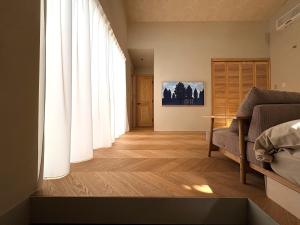 a living room with white curtains and a couch at トシマトビ in Toshima