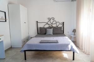 a bedroom with a large bed with a metal headboard at Rodostagma 1 in Rodholívos