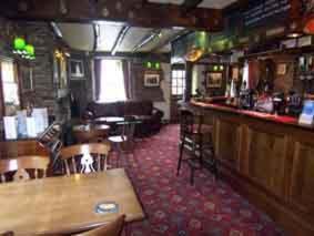 East LooeにあるThe Copley Armsのバー、テーブル、椅子が備わるレストラン