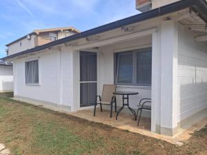 a patio with a table and chairs next to a house at White house in Donji Štoj +18 photos
