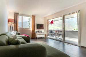 a living room with a couch and a large window at White Apartment in Andermatt