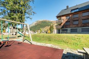 a swing on a patio in front of a building at White Apartment in Andermatt
