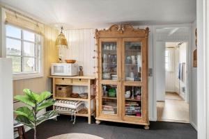 a kitchen with a wooden cabinet and a microwave at LF622-Hurup-Bakkesiden-22 in Hurup