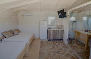 a room with a bed and a refrigerator and a sink at White house in Donji Štoj