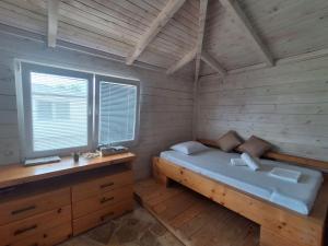 a bedroom with a bed in a wooden room at White house in Donji Štoj