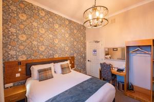 a bedroom with a bed and a desk in a room at The Goddard Arms in Swindon
