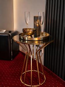 a gold table with two wine glasses on it at Nowad Hotel in Giurgiu