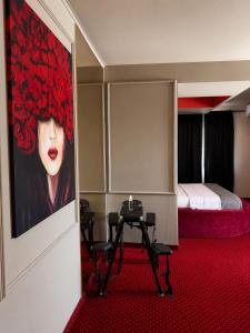 a room with a painting of a woman with red lipstick at Nowad Hotel in Giurgiu
