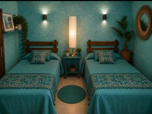 two beds in a room with blue walls at Santiago Apartment Mallorca in Cala Figuera