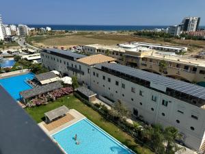 an aerial view of a building with a swimming pool at Nothern Cyprus Caesar Resort & Spa Collection Pools & Long Beach in Aglantzia