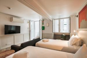 a hotel room with two beds and a flat screen tv at Pendoa Sintra Collection-Soft Opening in Sintra