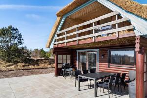 a patio with a table and chairs next to a house at 0132-Romo-Kap-Farvel-12 in Høm