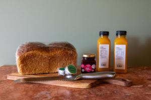 a cutting board with a loaf of bread and bottles of honey at The Monty in Anglesea