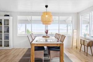 a dining room with a wooden table and chairs at LF15233-Hojslev-Jelsevej-261 in Højslev +16 photos