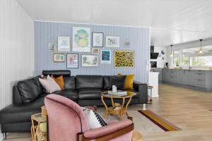 a living room with a black leather couch and a table at LF15233-Hojslev-Jelsevej-261 in Højslev