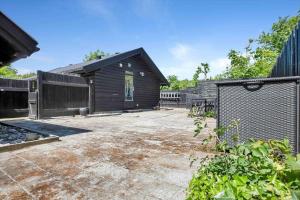 a black house with a fence in a yard at 13338-Asnaes-Hogevej-22 in Asnæs +15 photos