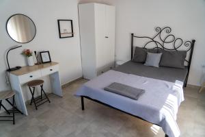 a bedroom with a bed and a desk and a mirror at Rodostagma 1 in Rodholívos +17 photos