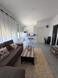 a living room with a couch and a coffee table at Spacieux et lumineux, coup de cœur garanti à proximité du métro et RER in La Courneuve