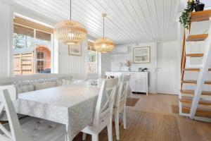 a dining room with a white table and chairs at 0025-Romo-P-J-Manosvej-18 in Høm