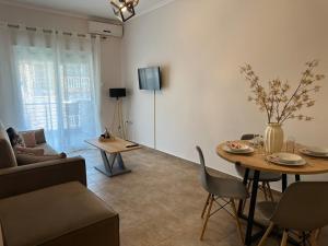 a living room with a table and a couch at Otium Apartment in Nea Peramos
