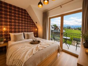 a bedroom with a large bed and a balcony at Golden Trio Villas in Ząb