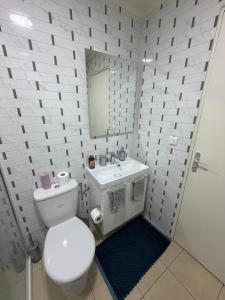 a white bathroom with a toilet and a sink at Spacieux et lumineux, coup de cœur garanti à proximité du métro et RER in La Courneuve
