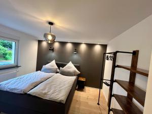 a bedroom with a bed with a black wall at Ferienhaus Kropsbach in Sankt Martin