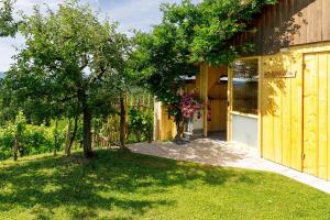 a house with a tree next to a building at Glamping Slavica in Dramlje