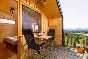 a wooden cabin with a table and chairs on a deck at Glamping Slavica in Dramlje +18 photos