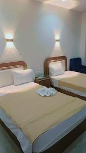 two beds sitting next to each other in a room at فندق الصفا السياحي سوهاج in Sūhāj +71 photos