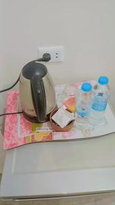 a tea kettle and bottles of water on a counter at فندق الصفا السياحي سوهاج in Sūhāj