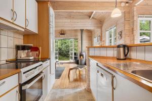 a kitchen with white appliances and wooden walls at LF16183-Logstor-Monasvej-1 in Løgstør