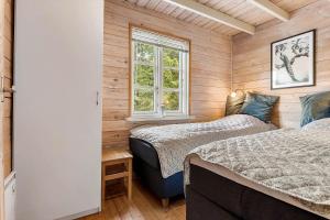 two beds in a room with wooden walls at LF16183-Logstor-Monasvej-1 in Løgstør