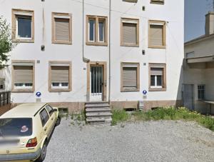 a white building with a car parked in front of it at Doux Pavillon - 1001 nuits - Jaccuzi in Mulhouse