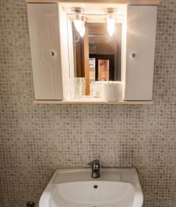 a bathroom sink with a mirror and a cabinet at Villa Maria in Ierissos +29 photos