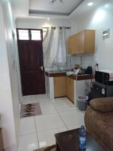 a living room with a kitchen and a door at Cossy Homes in Mtwapa