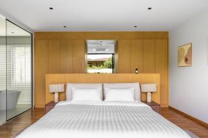 a bedroom with a large bed and a mirror at Botanica Zen by Villacarte in Ban Phru Champa +29 photos