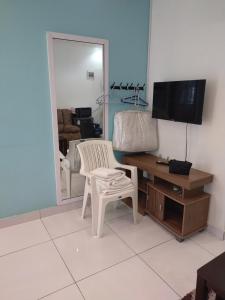 a living room with a chair and a desk with a television at Cossy Homes in Mtwapa