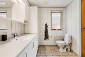 a white bathroom with a toilet and a sink at LF16244-Logstor-Mollysvej-44 in Løgstør +14 photos