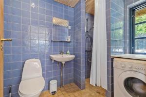 a blue tiled bathroom with a toilet and a sink at 16642-Farevejle-Vindekilde-Strandvej-30 in Fårevejle +23 photos