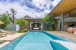 a swimming pool in the backyard of a house at Botanica Zen by Villacarte in Ban Phru Champa