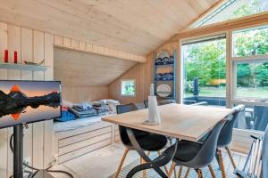 a room with a table and chairs in a tiny house at 13346-Hojby-Digevaenget-8 in Højby